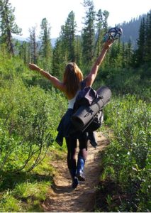 Glad kvinde på vandring med rygsæk