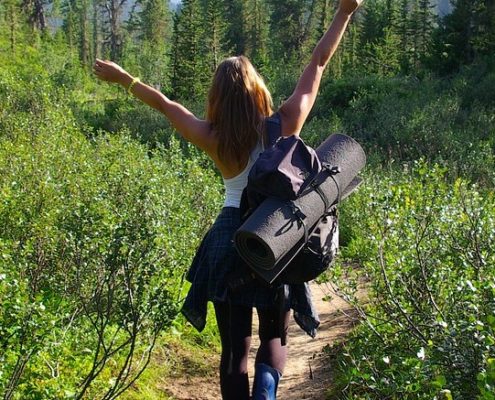 Glad kvinde på vandring med rygsæk
